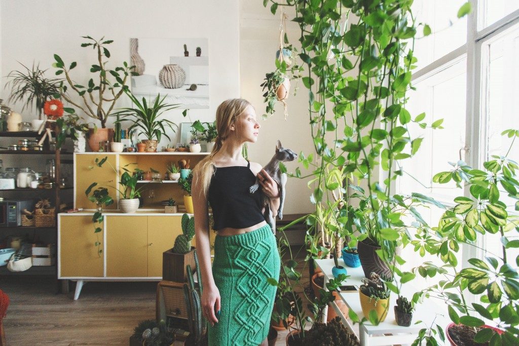 Woman surrounded by plants in the living room