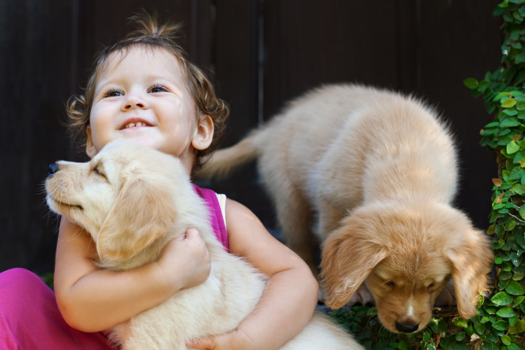 a child hugging a puppy